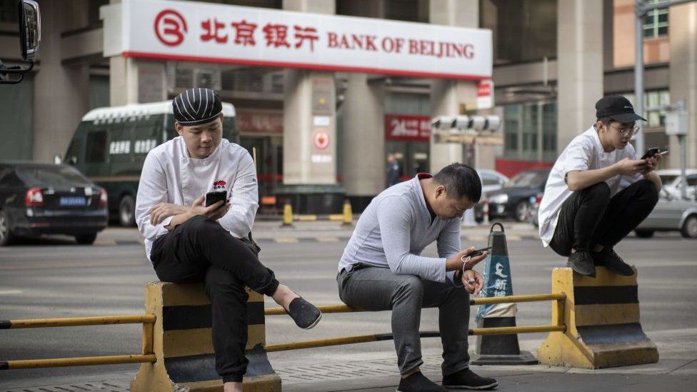Ciudadanos mirando el teléfono móvil en China.