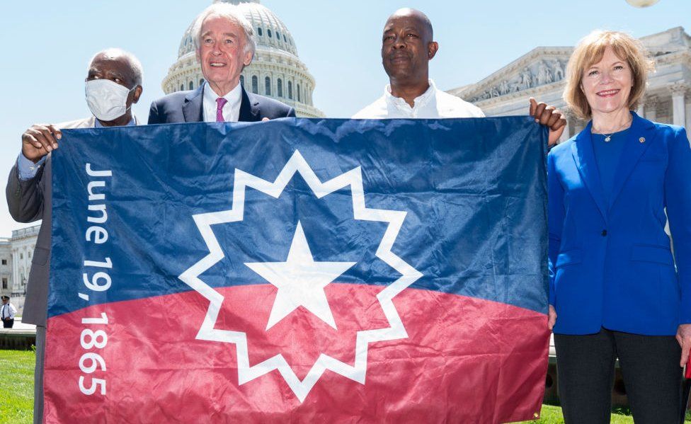 US lawmakers hold the holiday's official flag after the law passed Congress