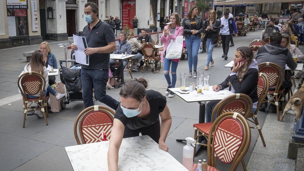 tables being cleaned at Di Maggio's outdoor restaurant area in Glasgow city centre.