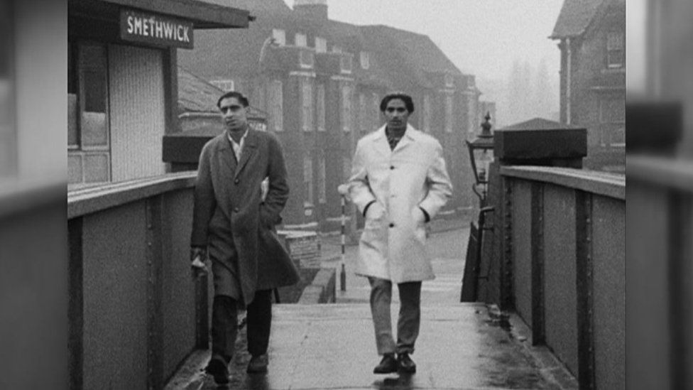 Two men walking along a bridge through Smethwick