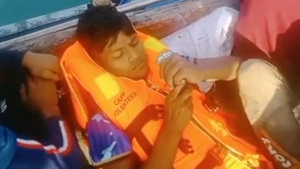 Rohingya refugee lying on a boat wearing a life jacket