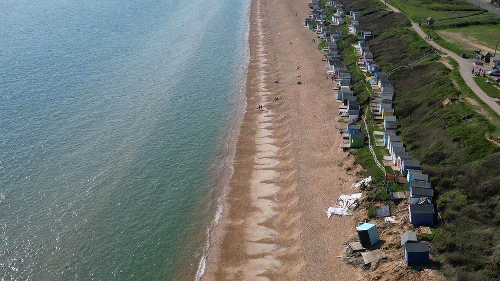 Drone footage of Hordle Cliff beach showing the two rows of huts on the right and the sea on the left