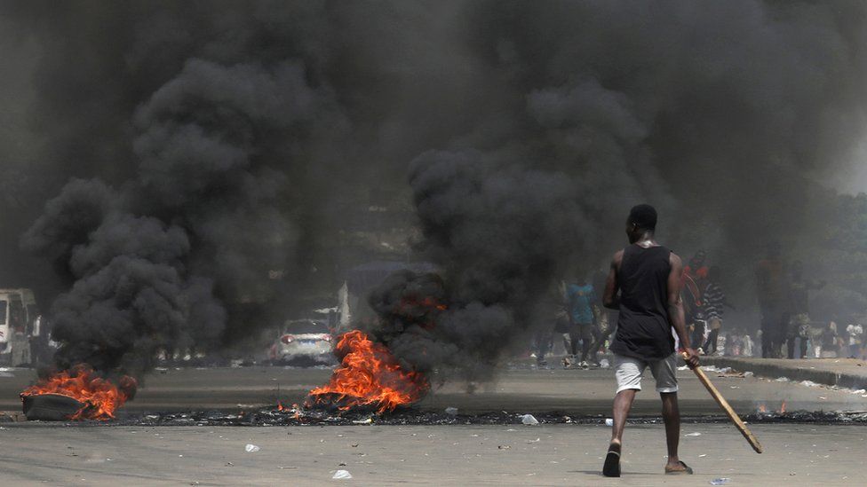 Anti-Gbagbo protesters block a street with burning tires