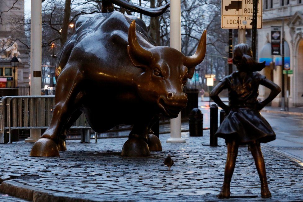 A statue of a girl facing the Wall St bull
