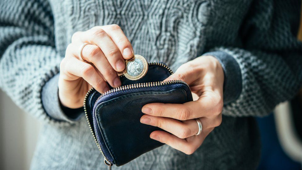 A woman putting coins in a purse