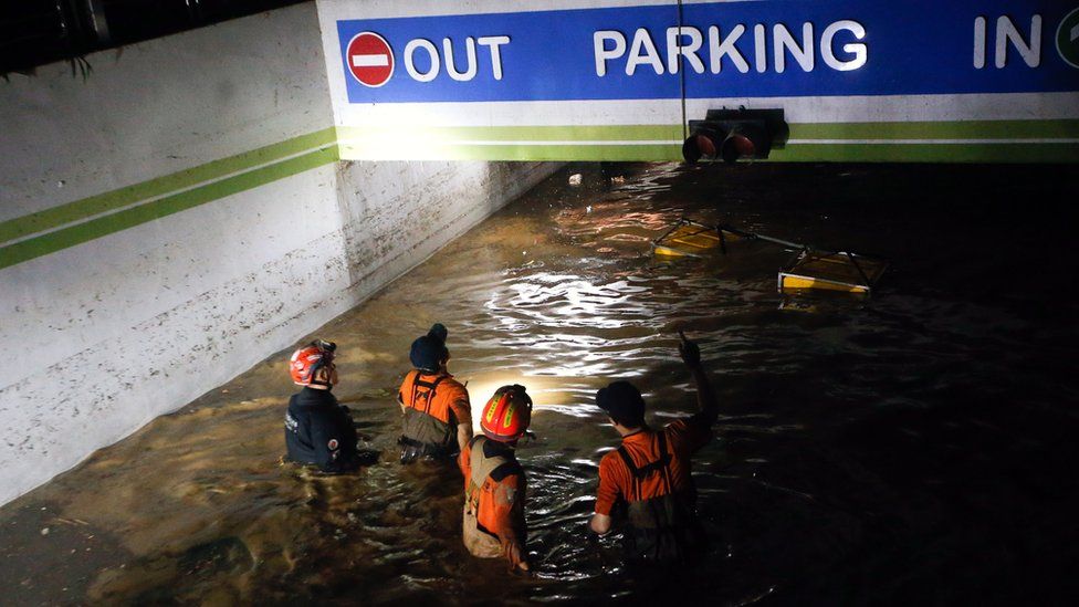 Firefighters and military officials search in an underground parking lot of an apartment in Nam-gu