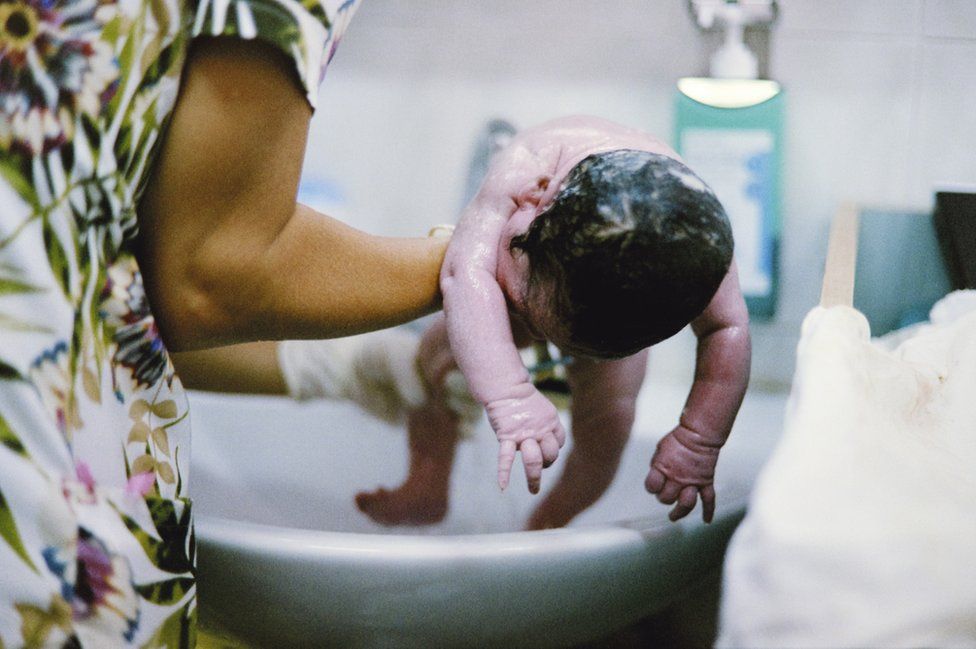 A midwife washing Sofia a few minutes after birth.