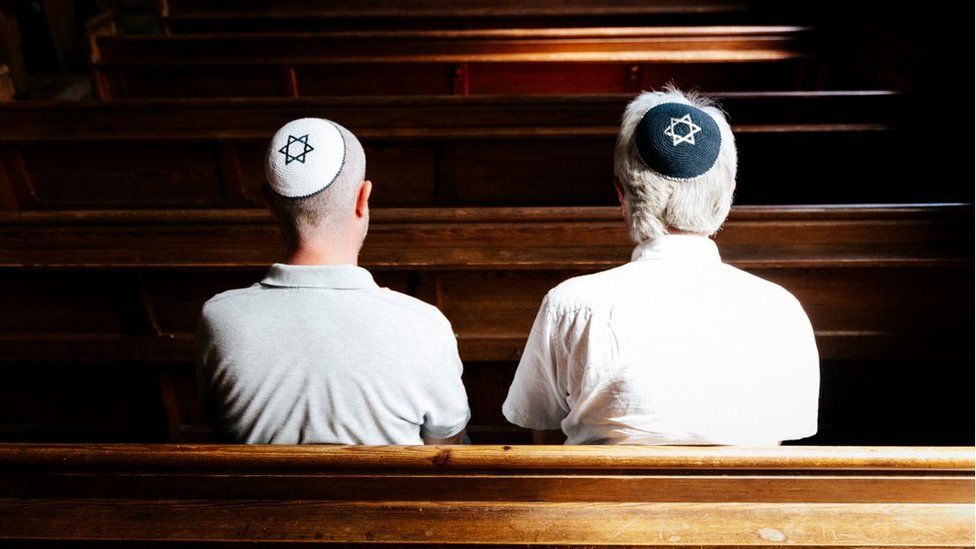 Two Jewish men on synagogue benches