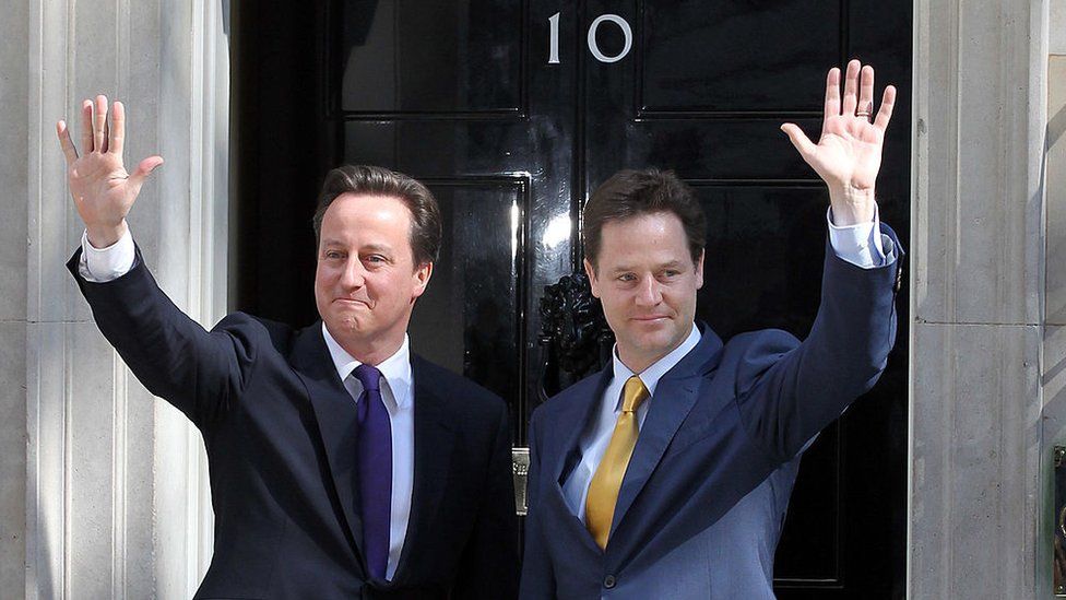 David Cameron (left) and Nick Clegg (right) wave to the press outside 10 Downing Street