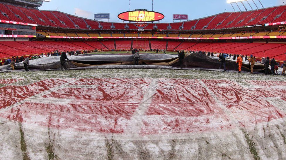 A view of the frozen field as the grounds crew removes the tarp in the brutal cold before an AFC Wild Card playoff game between the Miami Dolphins and Kansas City Chiefs on Jan 13, 2024 at GEHA Field at Arrowhead Stadium in Kansas City, MO.