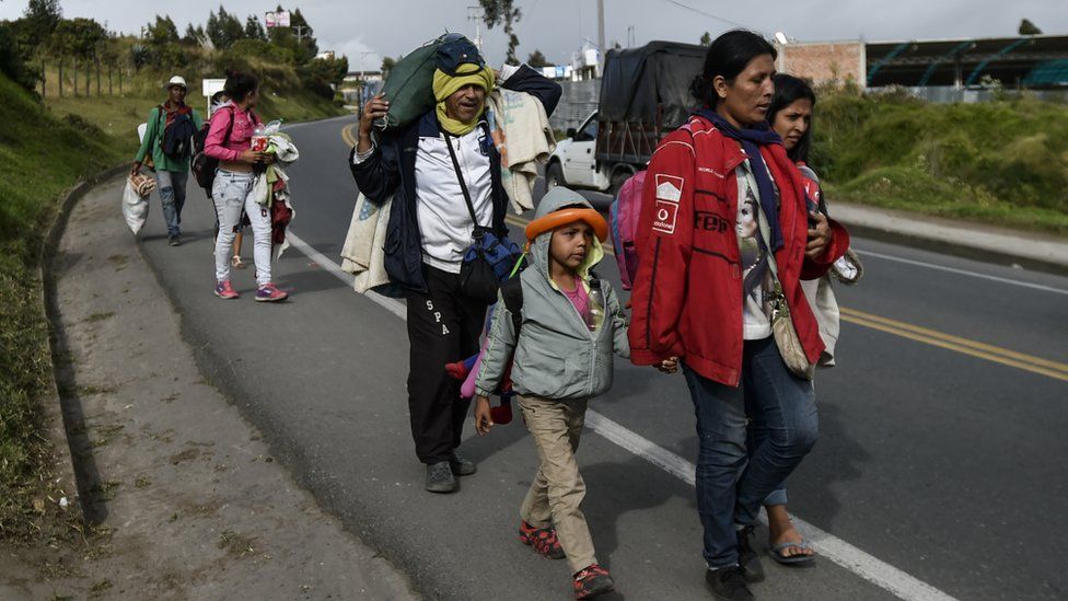 Venezuelan migrant Edith Landinez (C)walks with her children along the Pan-American highway, between Pasto and Ipiales in Colombia on their way to Peru