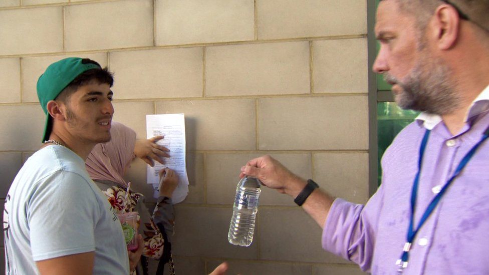 Passport Office staff hand out bottled water