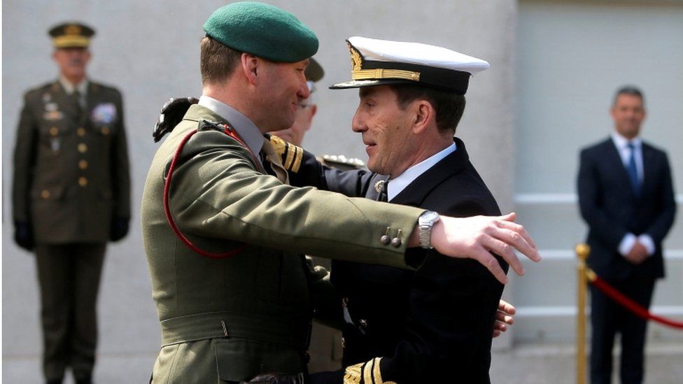 A UK and Spanish naval officer embrace at a ceremony of transfer of authority of the leadership from UK to Spain of European Union Operation Atalanta on 29 March 2019