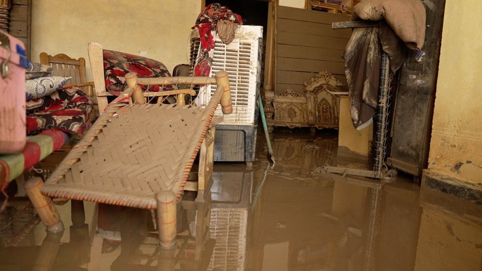 Waterlogged furniture and debris inside a flooded home in Nowshera