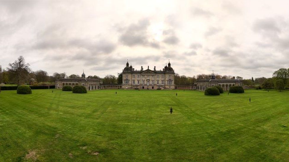 Wide shot shows Houghton Hall in the background with cast-iron figures dotted on the sprawling green lawn.