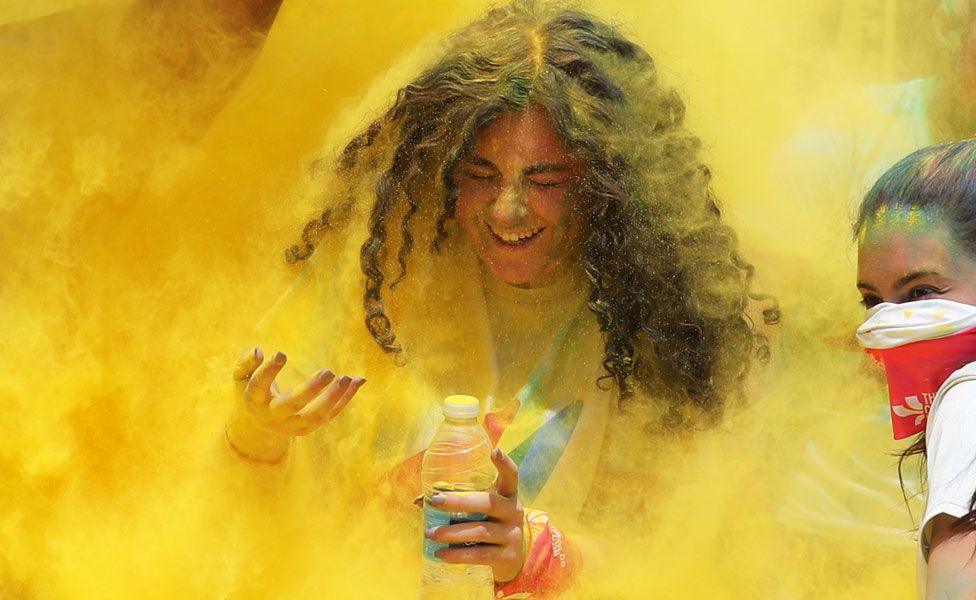 A young woman covered in yellow powder - Saturday 13 April 2019