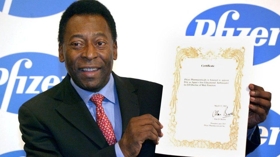 Brazilian football legend Pele shows a certificate as Japan's first educational ambassador for erectile dysfunction decline during a news conference in Tokyo in March 2002 to promote an anti-impotence awareness campaign