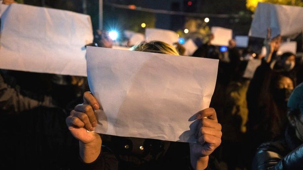 Protesters hold up a white piece of paper against censorship as they march during a protest against Chinas strict zero COVID measures on November 27, 2022 in Beijing, China