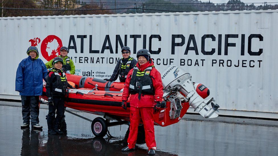 Volunteer crews in Japan with a lifeboat. Behind them in the shipping container made by Atlantic Pacific.