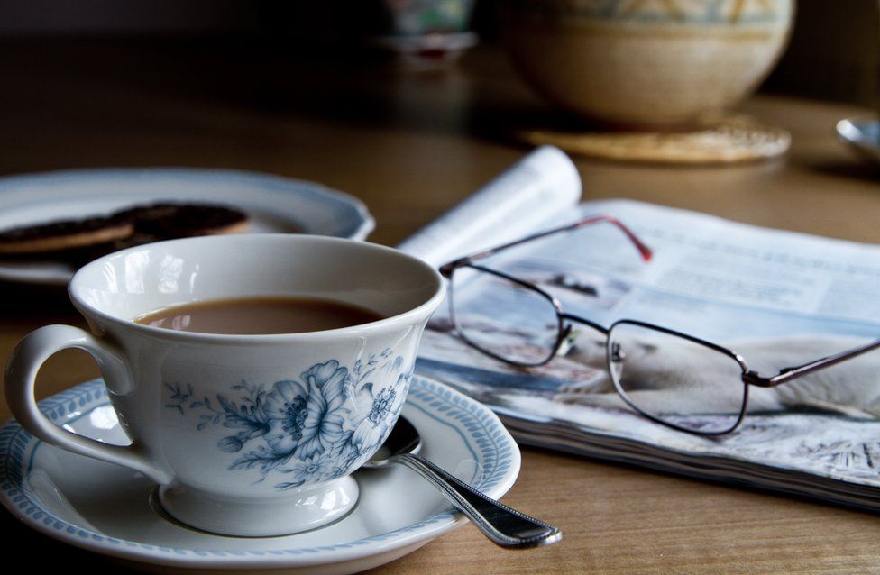 A cup of tea, newspaper and glasses