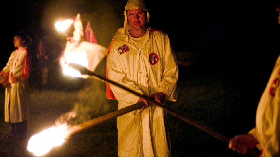 Ku Klux Klan members light torches as they begin a cross-lighting ceremony at the White Heritage Days Festival in Alabama in 2004.