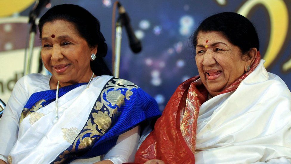 Лата Мангешкар (справа) сидит рядом со своей сестрой Ашей Бхосле во время церемонии вручения наград Пандита Хридайнатха Мангешкара в Мумбаи, 31 марта 2013 г.