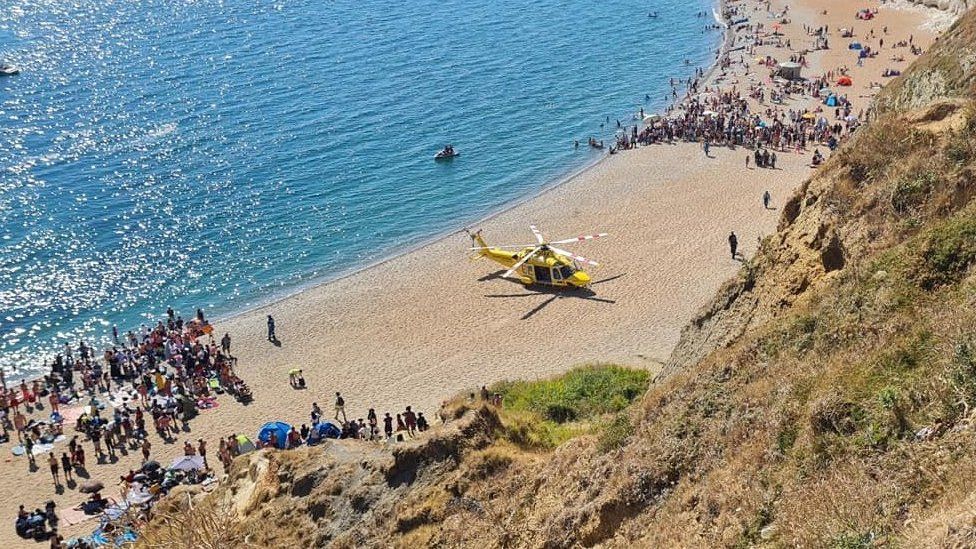 Air ambulance helicopter on the beach at Durdle Door