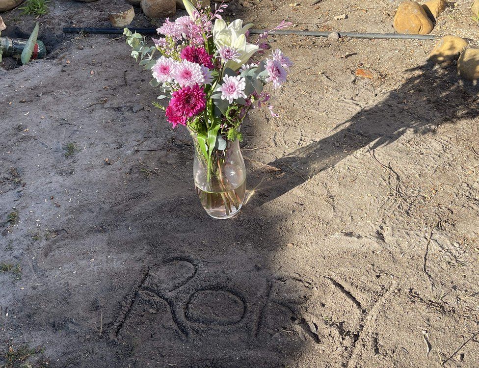 Vase containing fresh flowers placed next to gun victim Rory's ashes