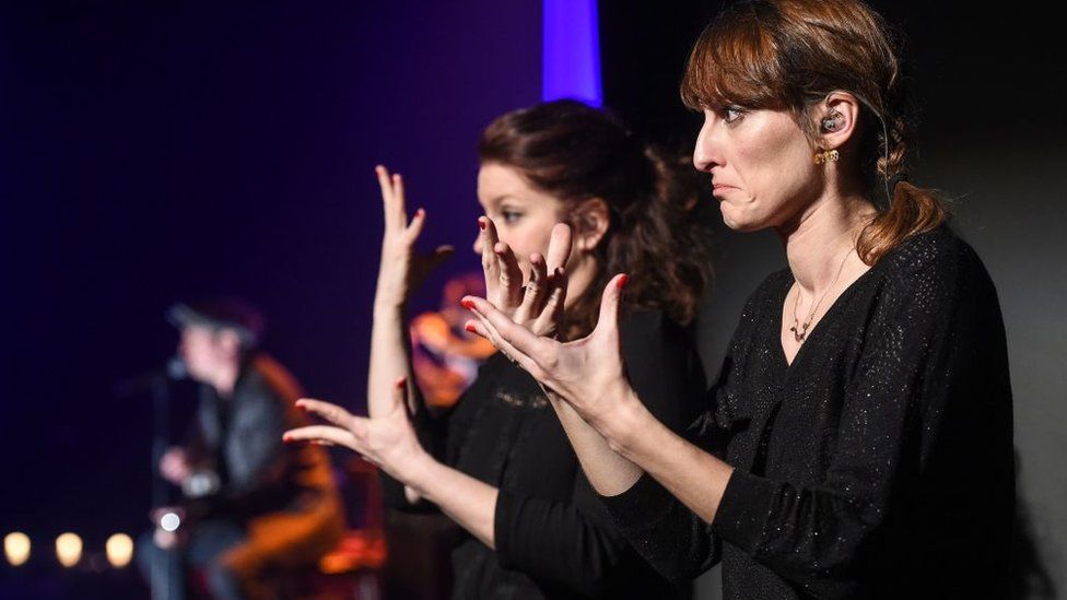 Interpreters perform for the hearing impaired during a concert of French singer Yves Jamait on March 23, 2017, in Sausheim.