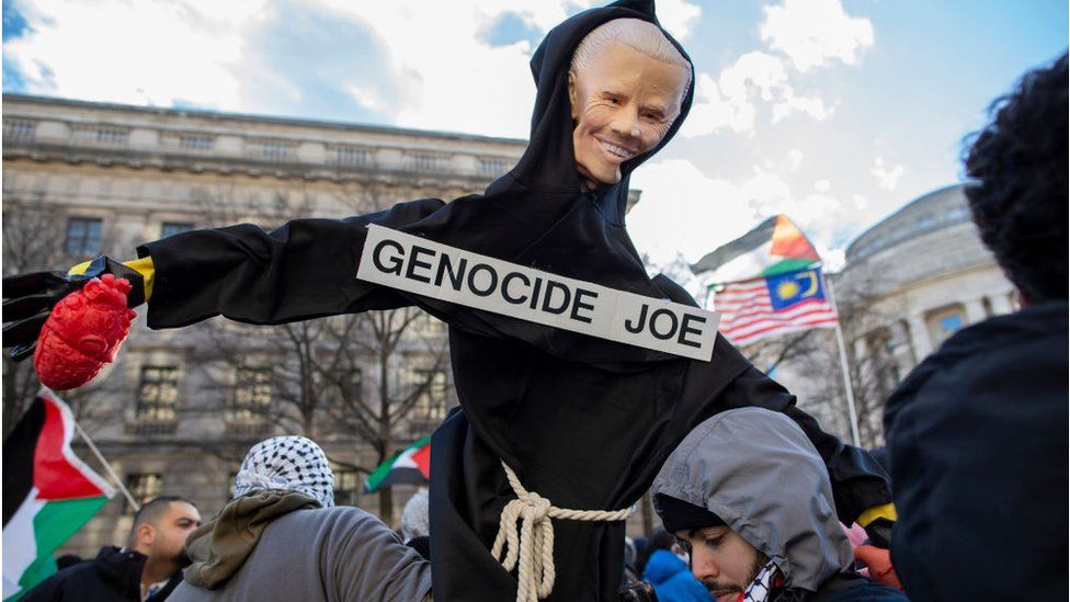 Un'effigie di Joe Biden con un cartello che dice "Genocide Joe" durante una protesta