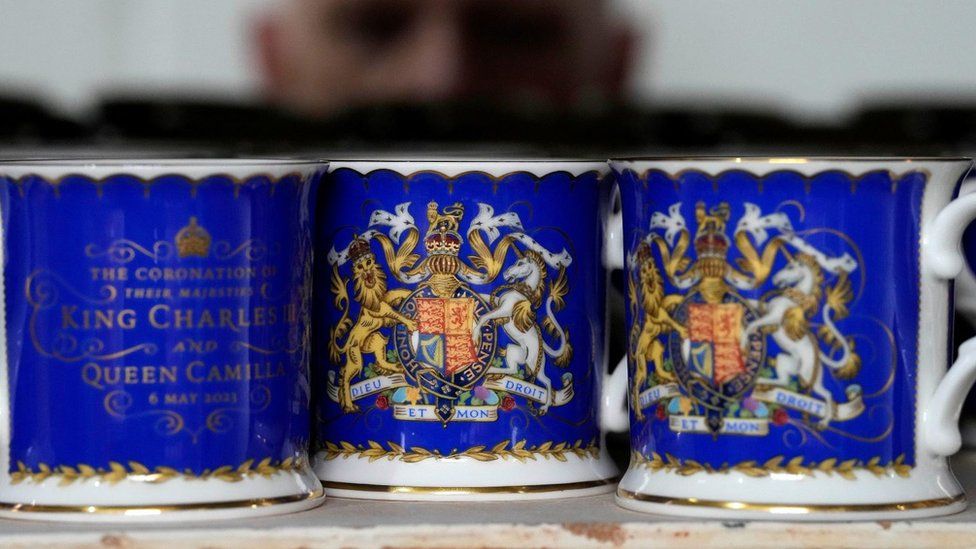 A worker checks the quality of official chinaware at a pottery factory in Stoke-on-Trent