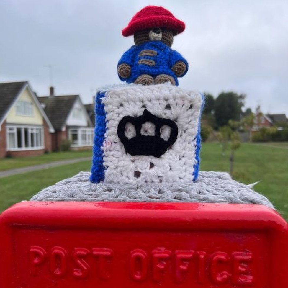 A hand-knitted Paddington Bear on top of a postbox in Farnsfield near Newark