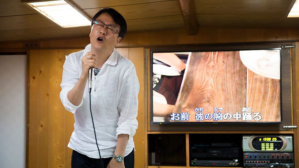 A customer sings a song using a karaoke machine