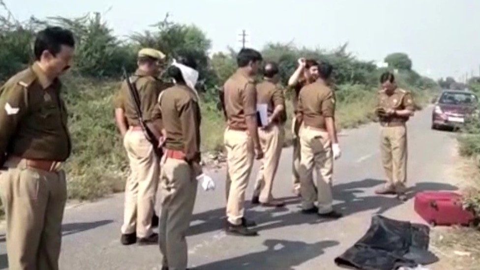 Police at the crime scene near Mathura with the red suitcase