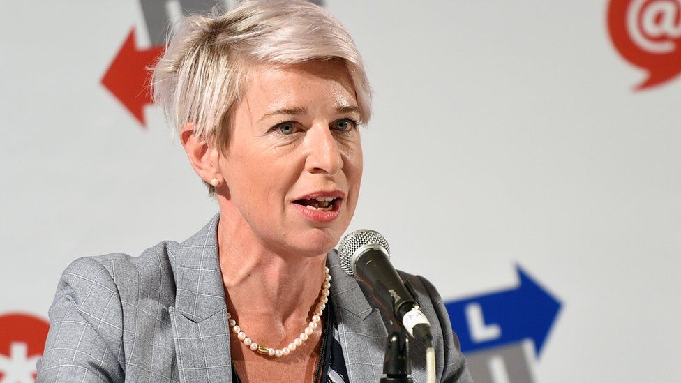 Katie Hopkins is seen sitting in front of a microphone
