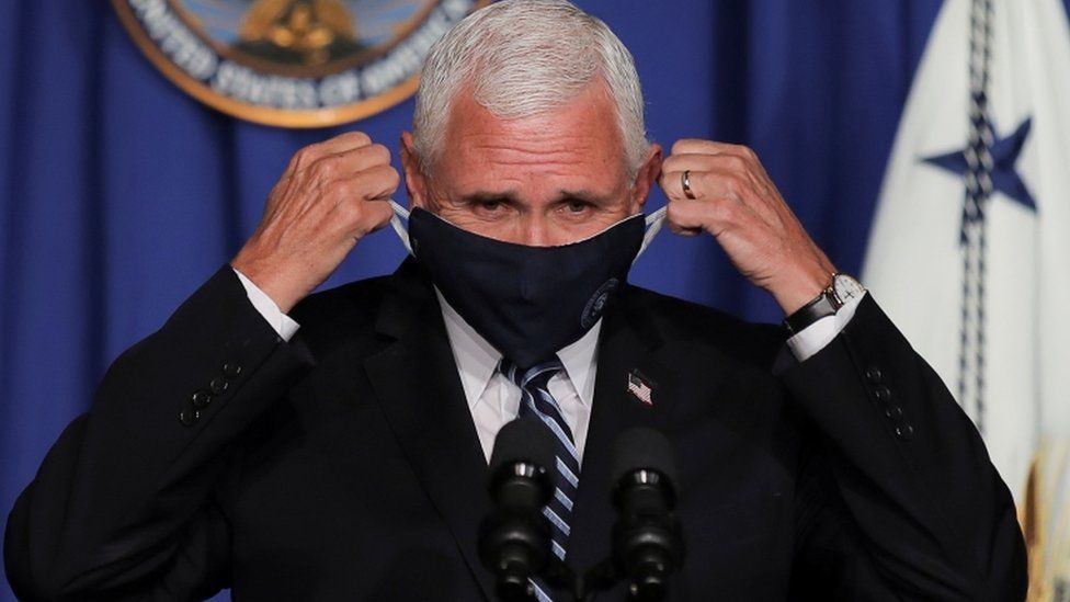 Vice President Mike Pence adjusts his protective face mask as he leads a White House coronavirus task force event