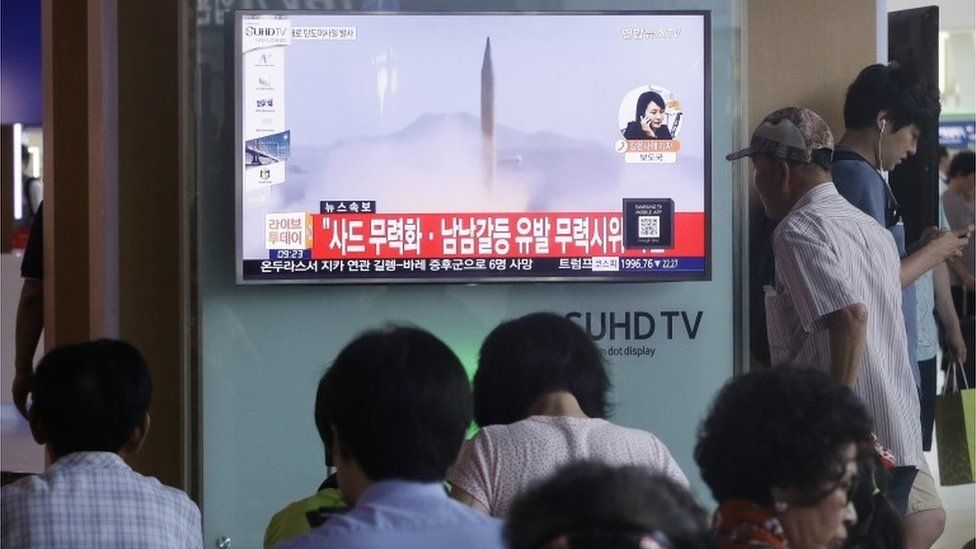 People watch a new report showing an archive North Korean rocket launch in Seoul (3 Aug 2016)