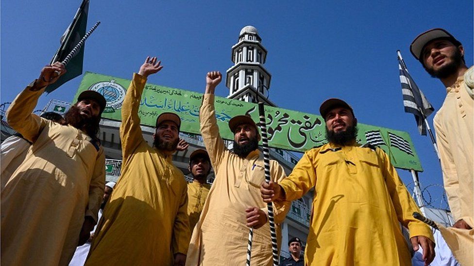 Activists of Jamiat-ul-Ulama-i-Islam and supporters of the Pakistan Democratic Movement (PDM) chant slogans as they leave for a rally held in Islamabad to protest against the judiciary's alleged undue facilitation to former Pakistan's Prime Minister Imran Khan, in Peshawar on May 15, 2023.