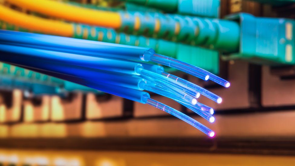 Оптоволоконный кабель свисает около портов Ethernet сервера