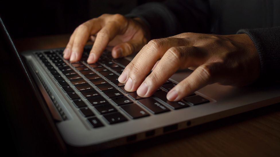 Stock image of hands typing on a laptop keyboard