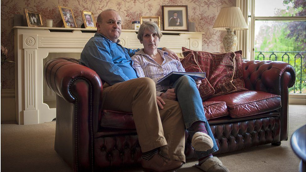 Ray and Alison Johnson at home in Wisbech. Elliott's graduation photograph sits behind them on the mantelpiece