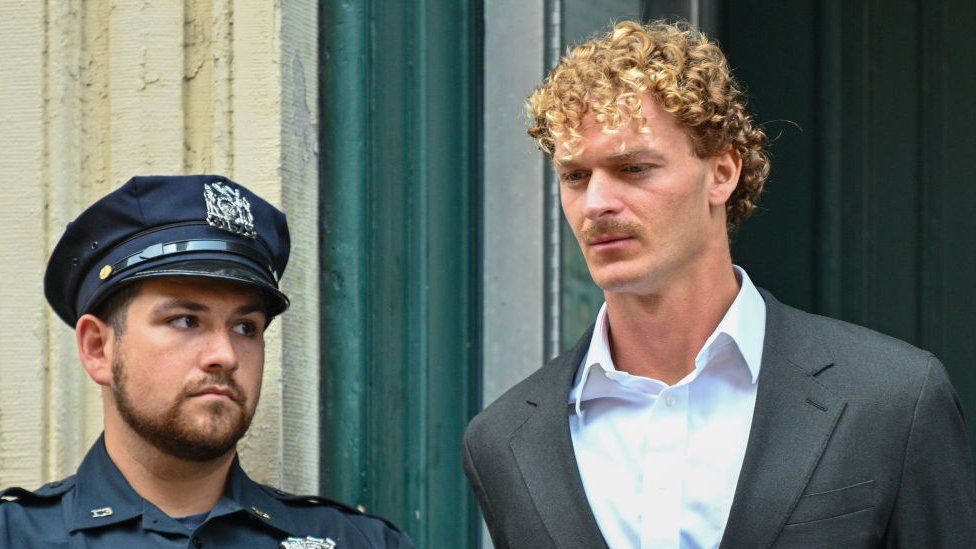 Daniel Penny is escorted in handcuffs by the NYPD after turning himself in in New York City on 12 May 2023