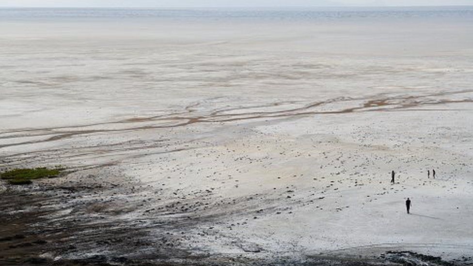 A family walks on the salt flat at Lake Urmia