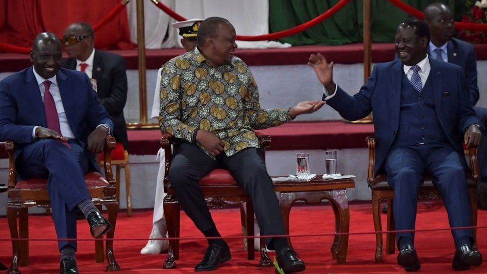 Kenya's President, Uhuru Kenyatta (C) reacts with opposition leader and former Prime Minister, Raila Odinga (R) on November 27, 2019