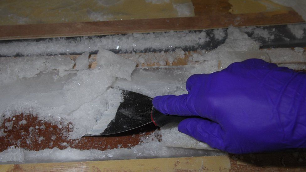 Police officers uncover drugs from between the floorboards