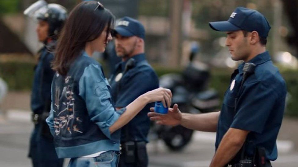 Kendall Jenner gives drink to officer