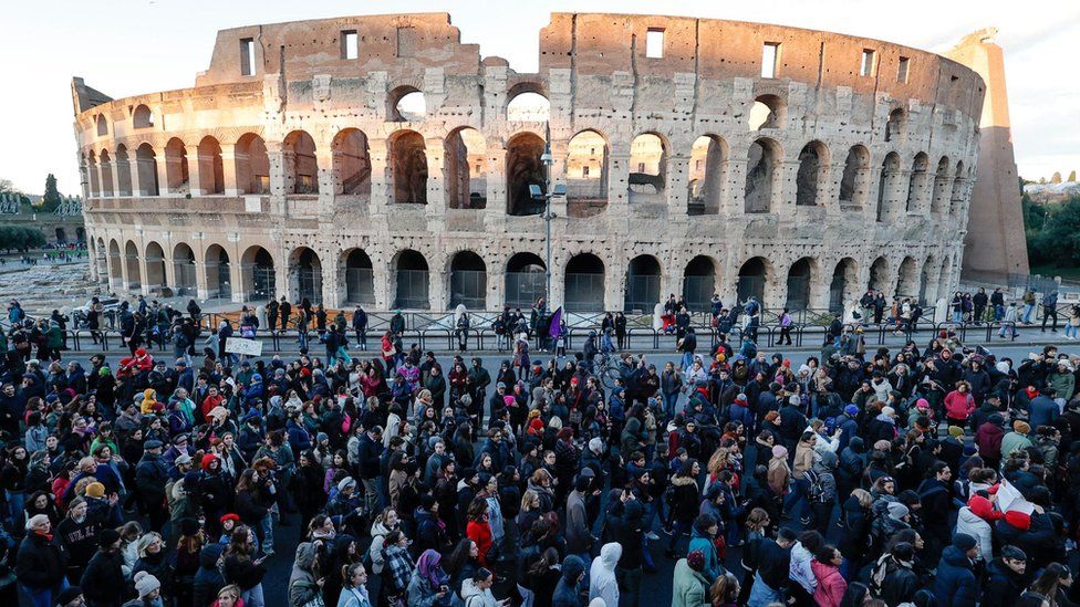 A large crowd of protesters marching past the Colosseum in Rome