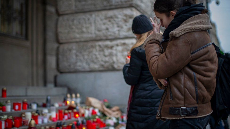A woman mourns outside the building of Philosophical Faculty of Charles University following a mass shooting earlier this week, on December 23, 2023 in Prague, Czech Republic.