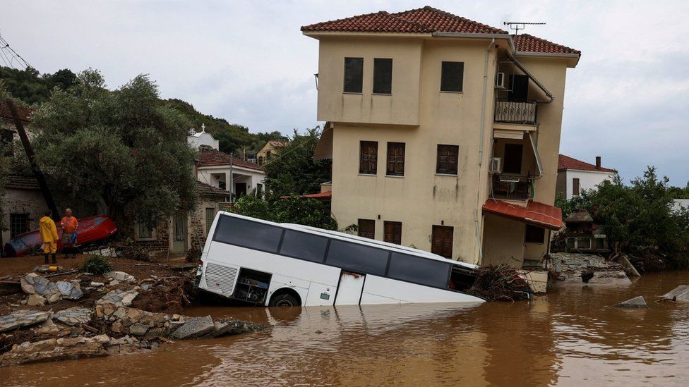 Автобус и дом частично затоплены в результате наводнения, вызванного ураганом Даниэль, обрушившимся на центральную Грецию