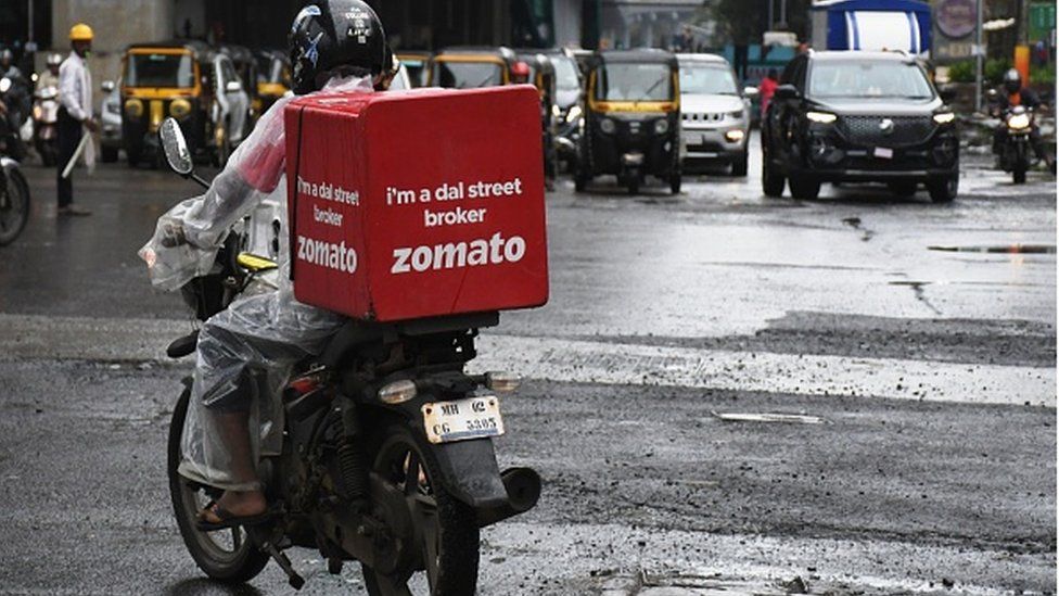 Доставщик Zomato едет по улицам Мумбаи.Онлайн-доставка еды Zomato выходит со своим первоначальным публичным предложением (IPO) 14 июля 2021 года
